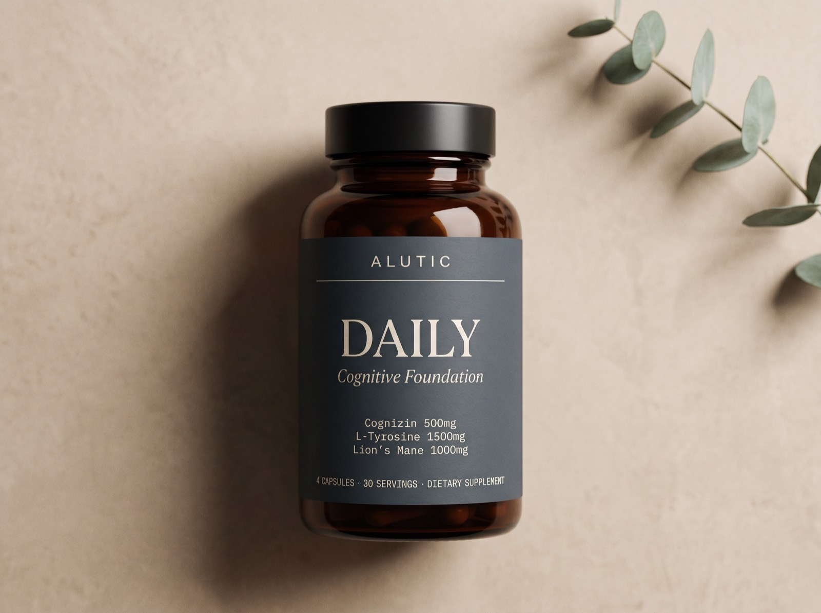 Alutic Daily, an amber glass supplement bottle with a dark slate label, photographed on a warm neutral surface beside a eucalyptus sprig.