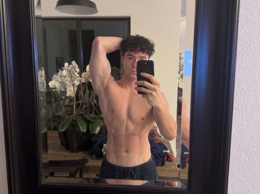 Before photo: young man in front of a mirror at home, baseline lean physique.