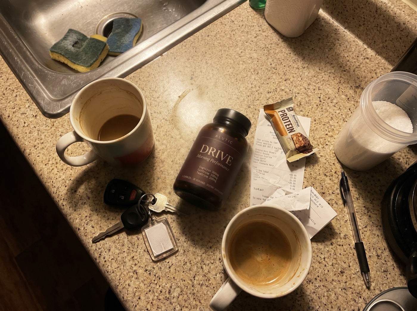 Customer photo: an Alutic Daily bottle on a kitchen counter beside two mugs of coffee, car keys and a receipt.