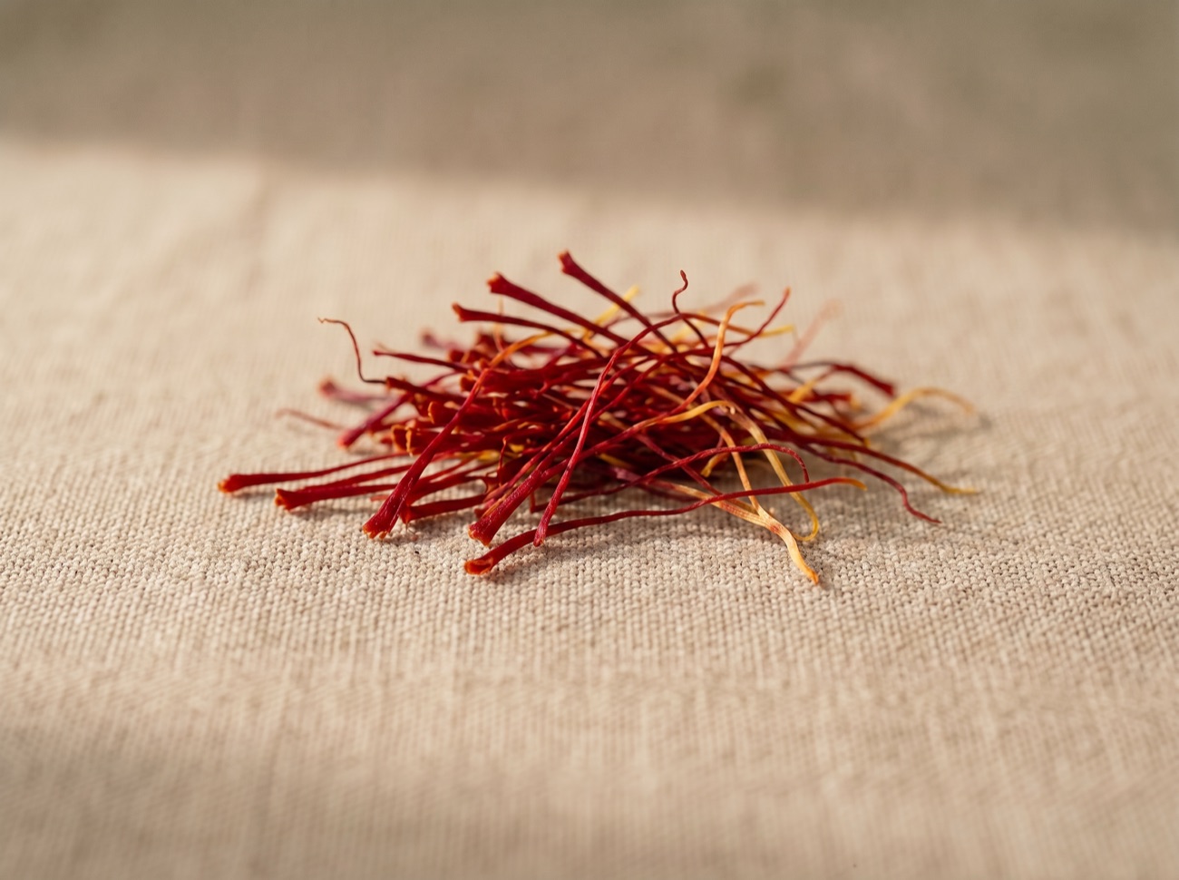 Saffron threads, the stigma extract standardised as Affron, on natural linen.